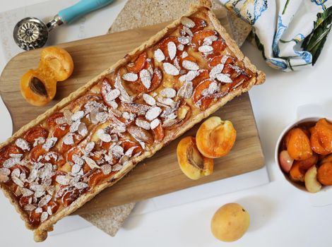 Homemade rectangular shortbread pie with apricots and peaches. White background