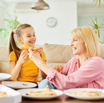 Family having meal, lunch or dinner, eating pizza and having fun at home