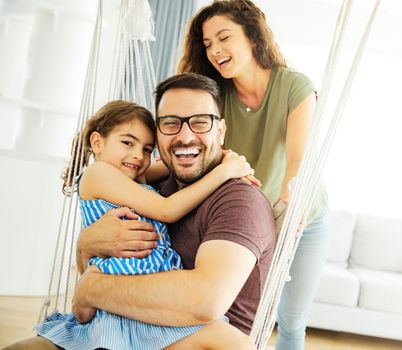 Family having fun playing on a swing at home