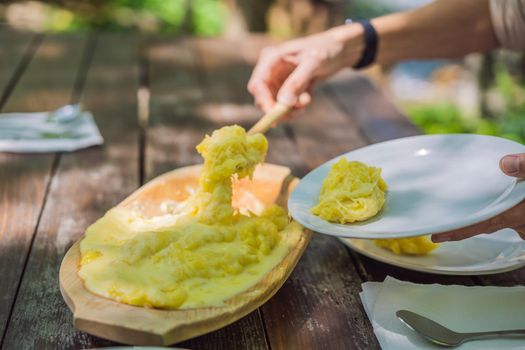 Traditional Montenegrin Meal. Kacamak in wooden bowl in the outdoor cafe.