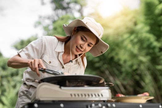 Young aisan girl grilling barbecue in the campground at summer camp travel, Skewers of pork and beef fillet on barbecue party in camping, Summer Camp Travel one activity for relaxing