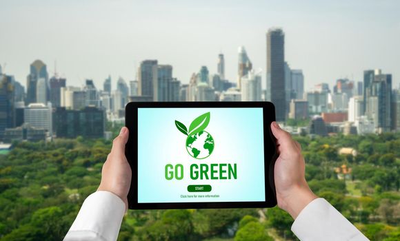 Green business transformation for environment saving and ESG business concept. Businessman using tablet to set corporate goal toward environmental friendly management and alternative clean energy use.