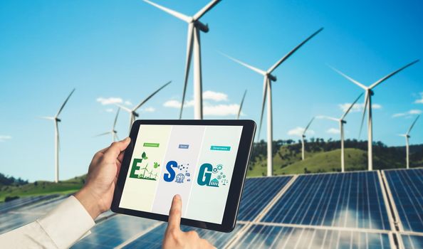 Green business transformation for environment saving and ESG business concept. Businessman using tablet to set corporate goal toward environmental friendly management and alternative clean energy use.