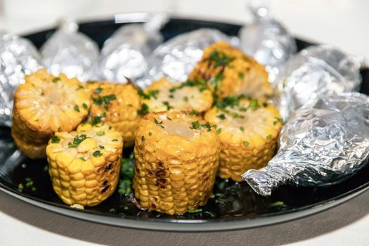 Grilled corn on the cob with green parsley. Tasty dish.