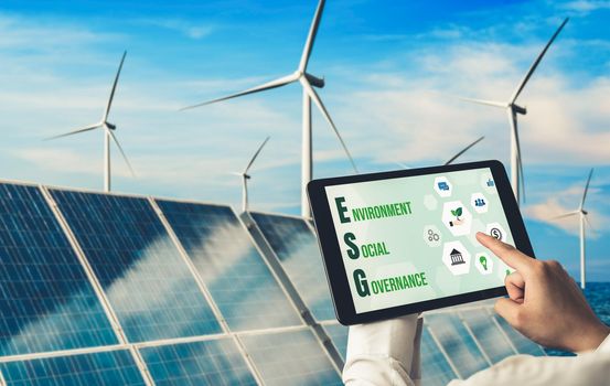 Green business transformation for environment saving and ESG business concept. Businessman using tablet to set corporate goal toward environmental friendly management and alternative clean energy use.