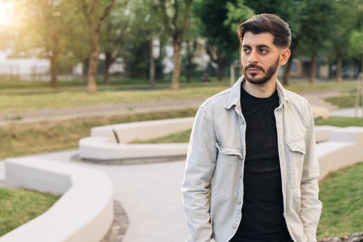 Bearded mixed-race elegant man with brown eyes. Caucasian european man looking stright outdoors. Stand outdoor relax. Happy relax. Male portraits.