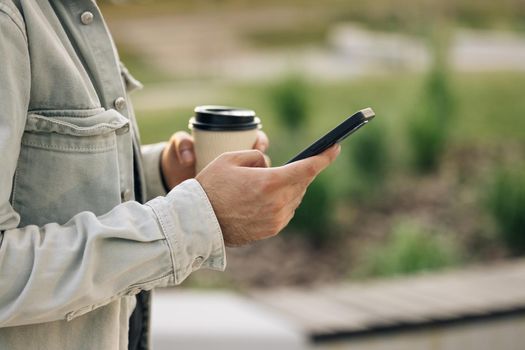 Close up view of unrecognizable male hands uses phone texting message, browsing surfinf internet tapping scrolling swipe up social media browsing isolated technology application.