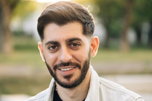 Close up portrait of caucasian bearded man face with white skin, smile look at camera open and confident. Guy wide smiling with healthy white teeth. Portrait of caucasian european male