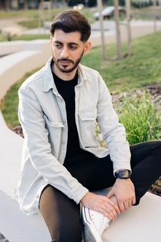 Gorgeous face of young bearded mixed-race elegant man with brown eyes. Beautiful caucasian european man looking stright outdoors. Outdoor relax. Happy relax. Male portraits