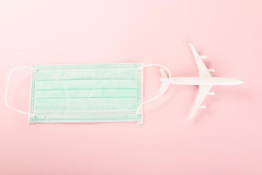 World Tourism Day, Top view model plane and medical face mask, Holiday accessory beach trip travel vacation studio shot isolated pink background with copy space