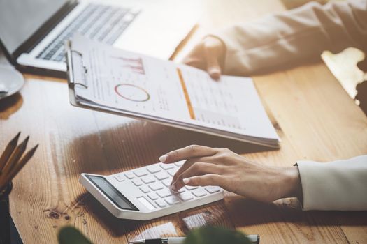 financial, Planning, Marketing and Accounting, Asian woman Economist using calculator to calculate investment documents.