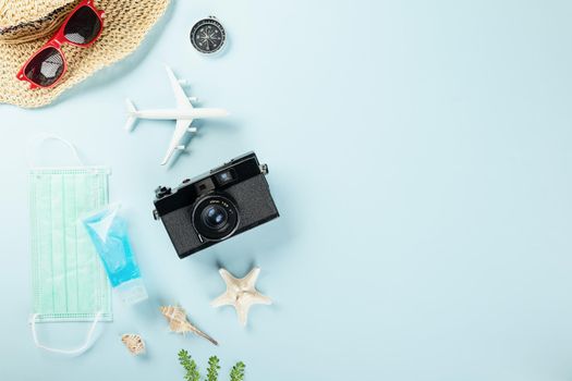 World Tourism Day during coronavirus pandemic, Travel accessories objects flat lay, studio shot isolated blue background with copy space, holiday trip vacation concept