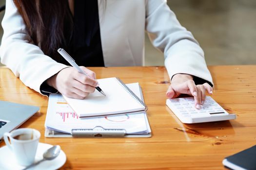 financial, Planning, Marketing and Accounting, Asian woman Economist using calculator to calculate investment documents.