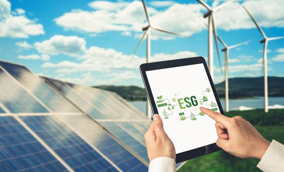 Green business transformation for environment saving and ESG business concept. Businessman using tablet to set corporate goal toward environmental friendly management and alternative clean energy use.