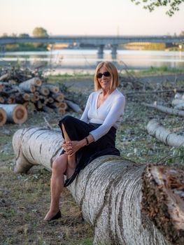 senior fit elegant lady dressed blaka dn white wearing sunglasses enjoying nature in summer