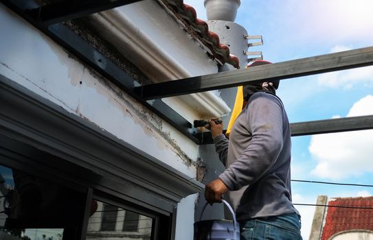 A mechanic is using a paint to paint the steel in matte black.