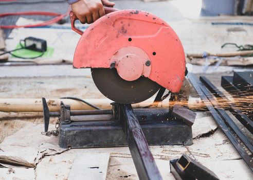 The technician uses a hacksaw to cut steel.