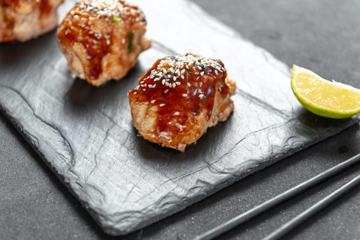 teriyaki chicken on a slate with sesame seeds. Asian Cuisine.