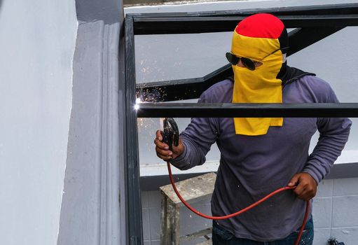 The welder is welding the steel structure to add to the house.