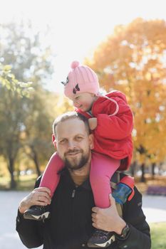 Happy father and child spending time outdoors. father with daughter in autumn park.