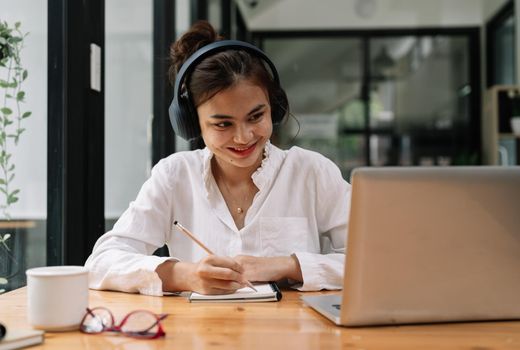 close up of Student learning online class by using laptop computer and writing notebook at workplace, E learning and online working concept