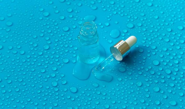 Bottle of cosmetics and drops of liquid, moisturizing. Hyaluronic acid. Selective focus. Spa.