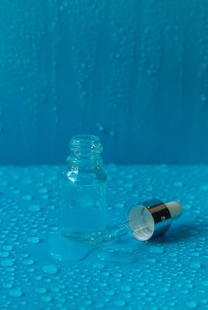 Bottle of cosmetics and drops of liquid, moisturizing. Hyaluronic acid. Selective focus. Spa.