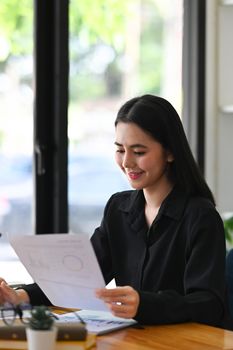 Portrait smiling businesswoman working in bright office.