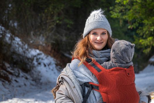 Babywearing mother winter outdoor with copy space.
