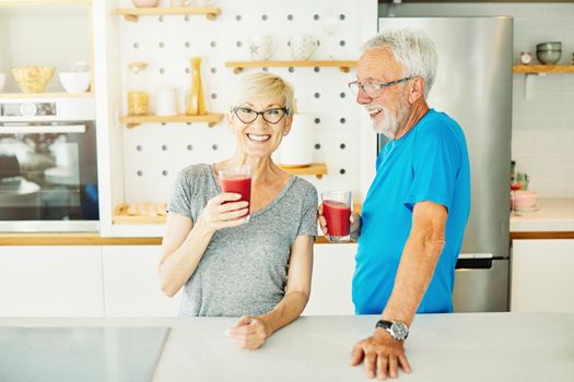 Happy senior couple enjoying breakfast nad healthy juice iafter the exercise in the morning