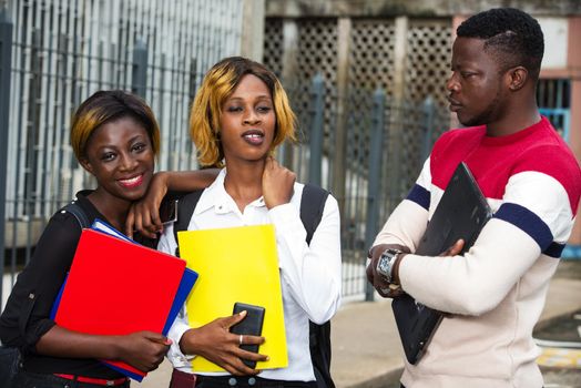 students standing in the street after class talking with a smile.