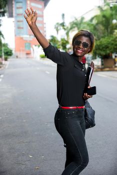 young student standing in glasses on the street after class greeting with a smile.