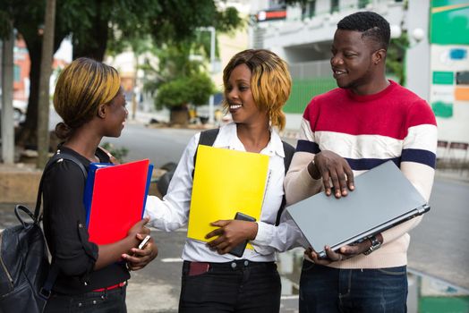 students standing in the street after class talking with a smile.