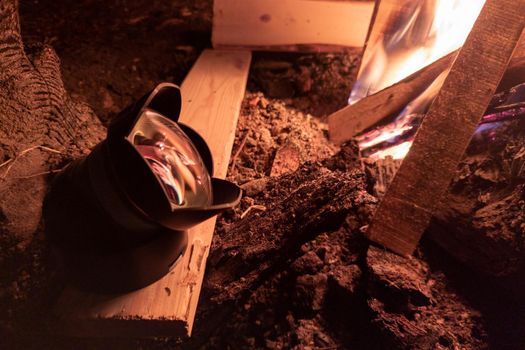 ultra-wide angle lens warming up near campfire at night to avoid condensation during following photoshoot