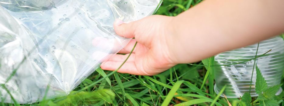 Used empty plastic bag in hands of a little girl while cleaning the park from debris