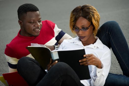 young students embracing to look at notebook smiling.