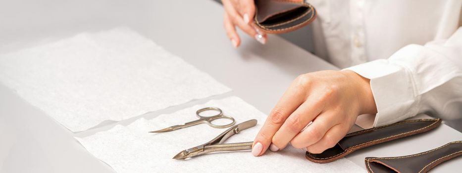 Manicurist's hands lay down manicure tools on table preparing for manicure procedures