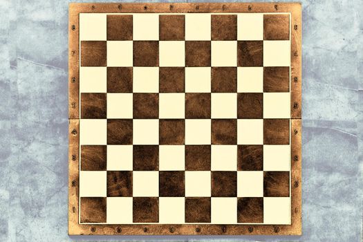 a square board divided into sixty-four alternating dark and light squares, used for playing chess or checkers. Brown dark chessboard on a gray marble surface