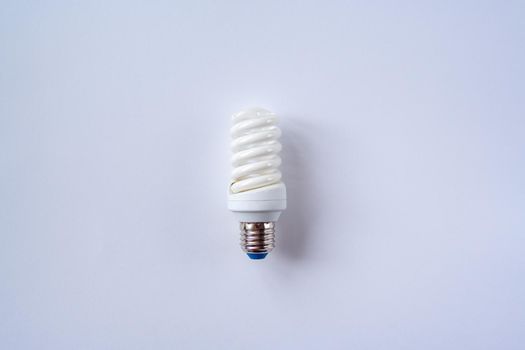 Energy saving light bulb on a blue background. Economical consumption of electricity. The concept of nature conservation