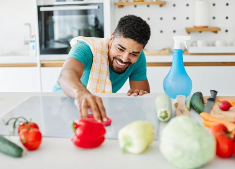 Portrait of a young happy black man cleaning kitchen