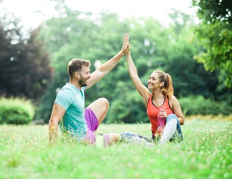 Portrait of a young couple exercising in a park outdoors