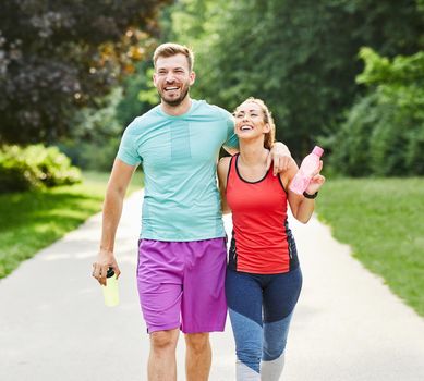 Portrait of a young couple exercising in a park outdoors