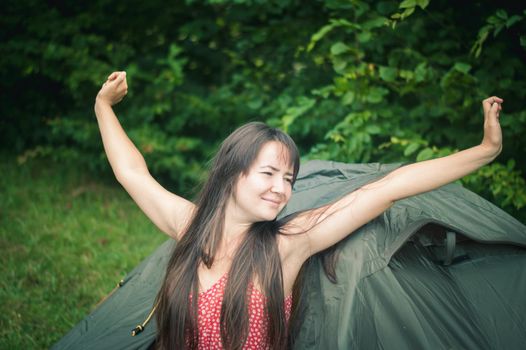 woman among the mountains near the tent enjoys nature. High quality photo