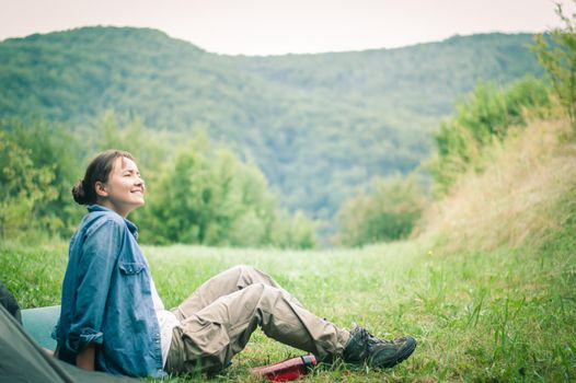 woman among the mountains near the tent enjoys nature. High quality photo