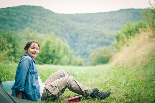 woman among the mountains near the tent enjoys nature. High quality photo