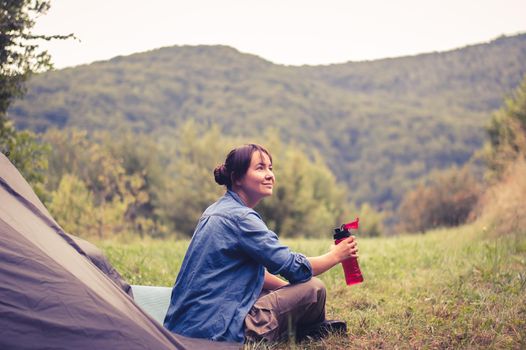 woman among the mountains near the tent enjoys nature. High quality photo