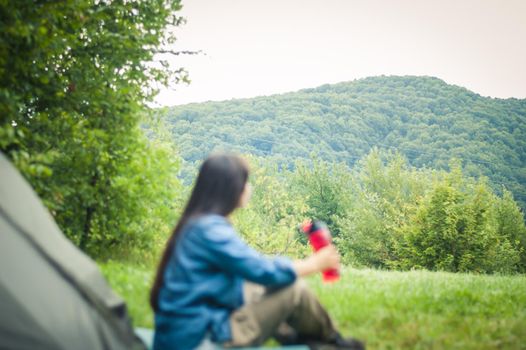 woman among the mountains near the tent enjoys nature. High quality photo