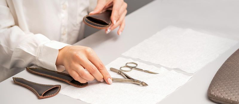 Manicurist's hands lay down manicure tools on table preparing for manicure procedures