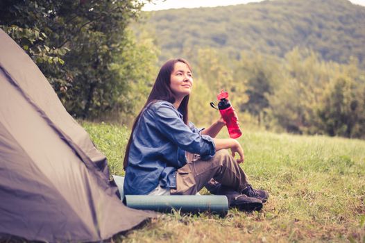 woman among the mountains near the tent enjoys nature. High quality photo