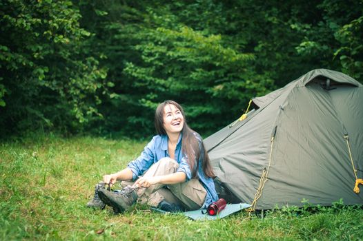 woman among the mountains near the tent enjoys nature. High quality photo